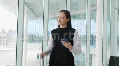 女游客在国际机场航站楼携带行李使用智能手机。 语<strong>音</strong>识别<strong>短信</strong>命令